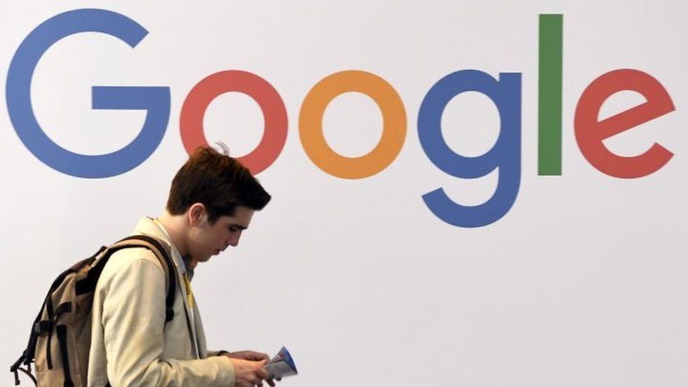 Человек проходит мимо логотипа Google.