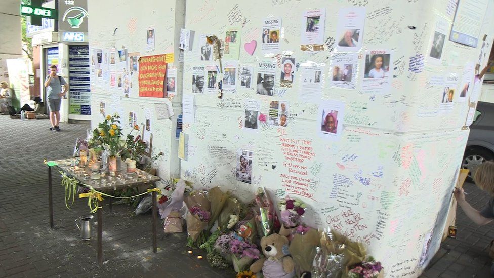 Posters and written tributes line the walls of a pillar near Grenfell Tower