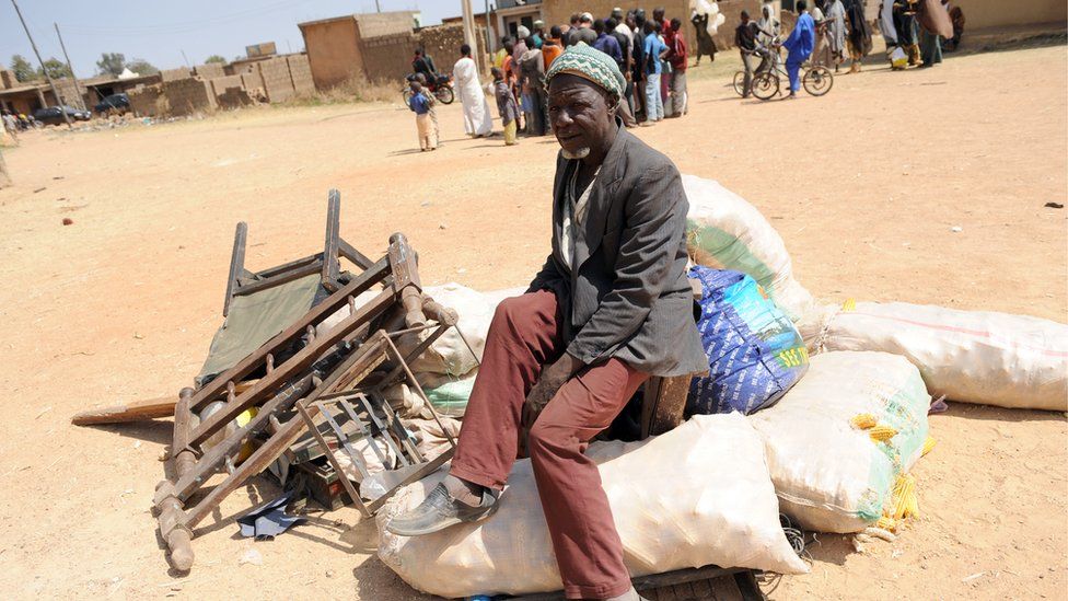 A displaced man sits on his household in Jos, Plateau State