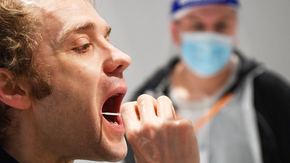 A man puts a swab in his mouth