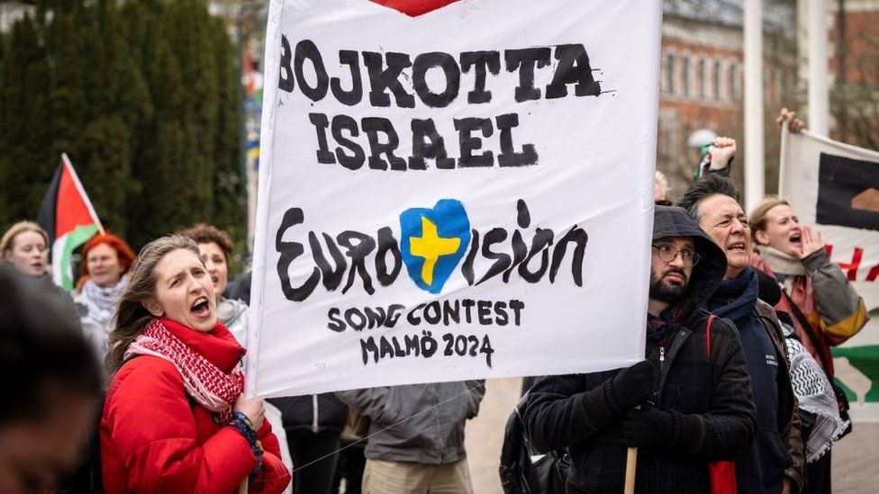 2024 年 4 月 10 日，抗议者在主办城市马尔默举着横幅，批评以色列参加 2024 年欧洲歌唱大赛