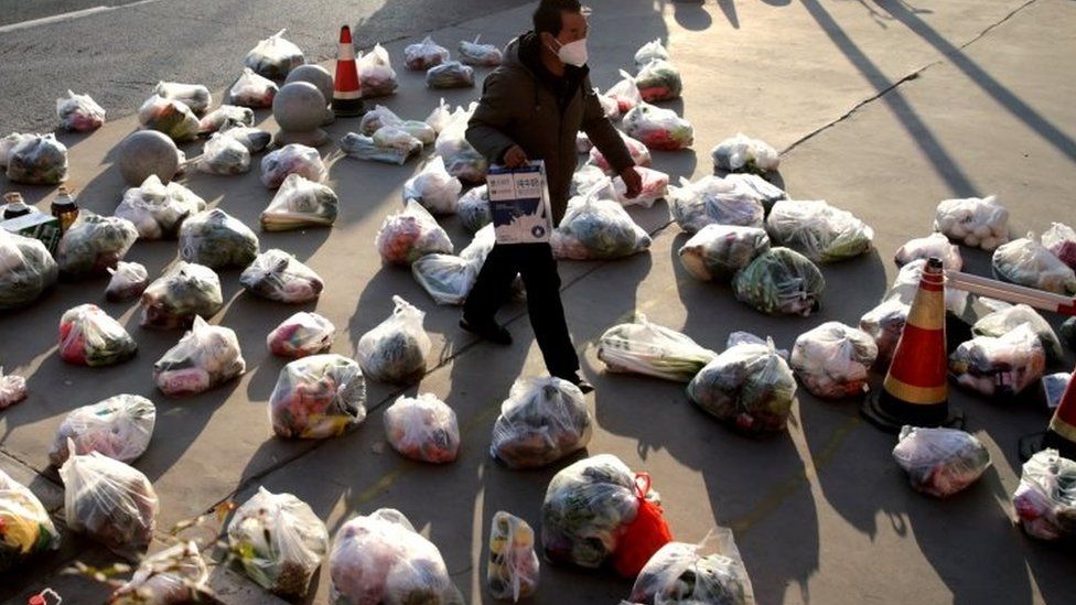 Рабочий готовится отправить продовольствие людям в Сиань