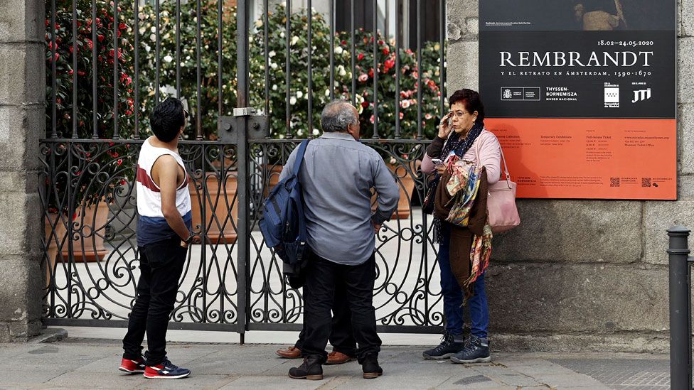 People look at closed doors of Prado museum in Madrid - 12 March