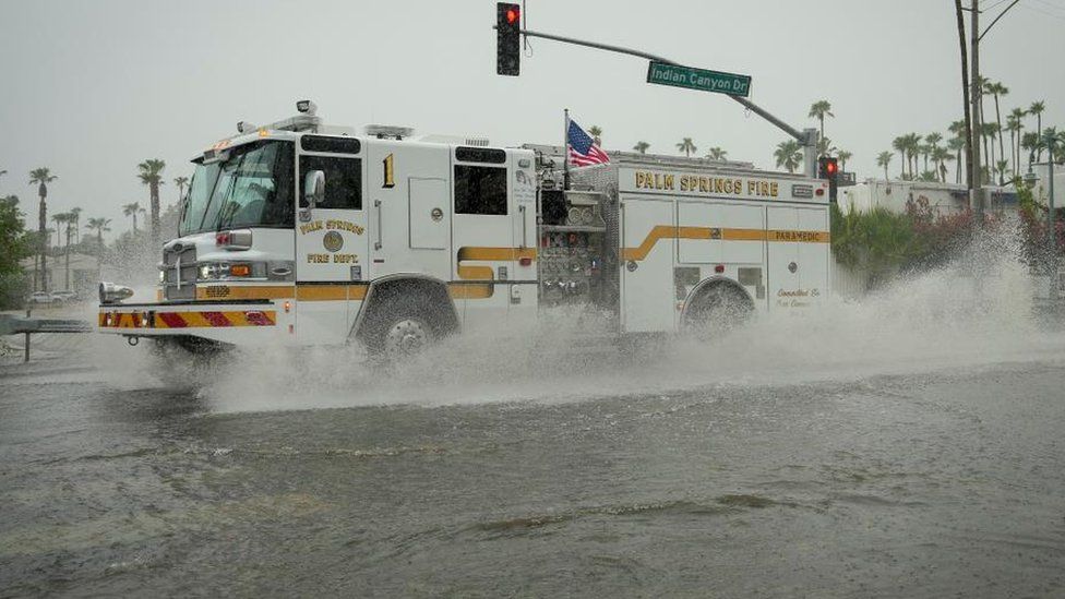 A fire engine moves through standing water on Indian Canyon Drive