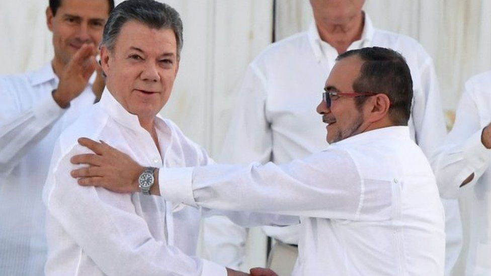 President Santos and Timochenko shaking hands after signing the deal