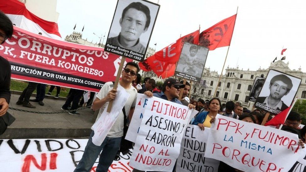 People holding banners and pictures of victims of the guerrilla conflict in the 1990s protest at Mr Fujimori's pardon (25/12/2017)