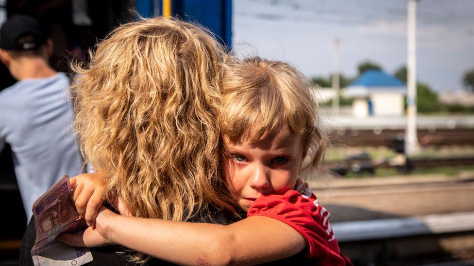 Ein ukrainisches Flüchtlingskind umarmt seine Mutter