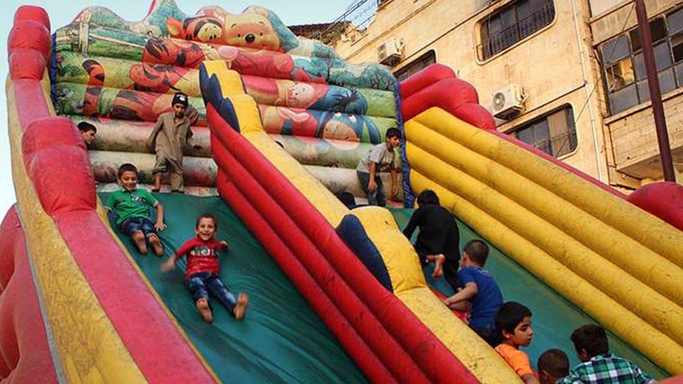 Children playing on a bouncy slide in Tabqa in 2015