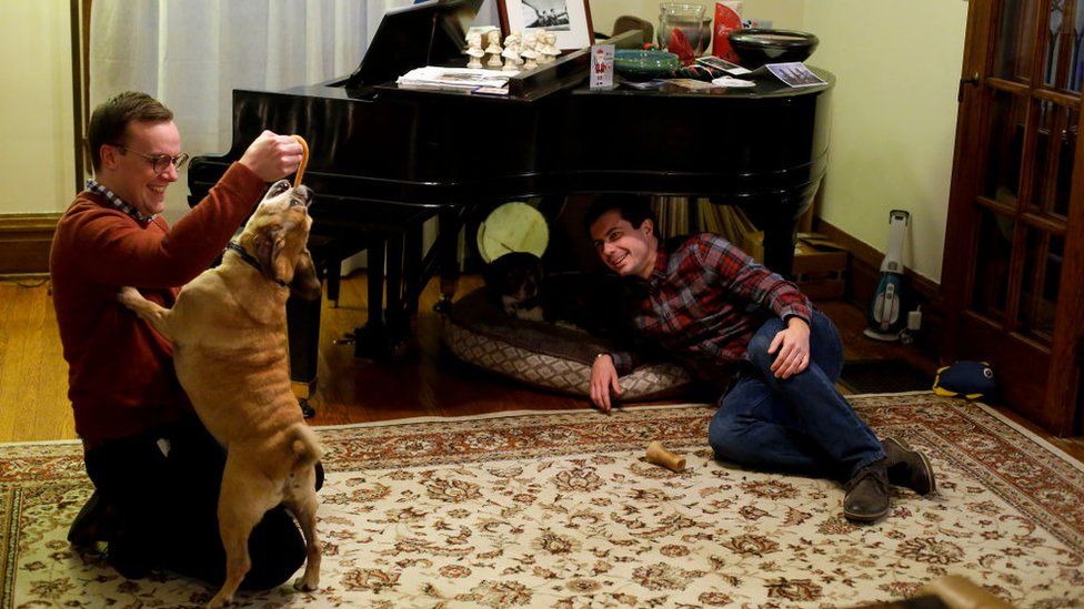 Mr Buttigieg with his husband Chasten Glezman and their dog Buddy at their Indiana home