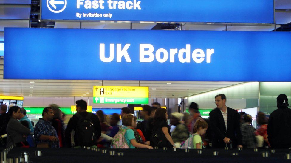 The UK border sign and queues at Heathrow Airport