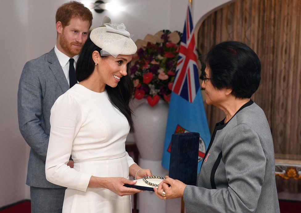 Meghan, Duchess of Sussex is presented with a pearl necklace from Sarote Faga Konrote as Prince Harry, Duke of Sussex looks on during the first day off their tour to Fiji on October 23, 2018 in Suva, Fiji