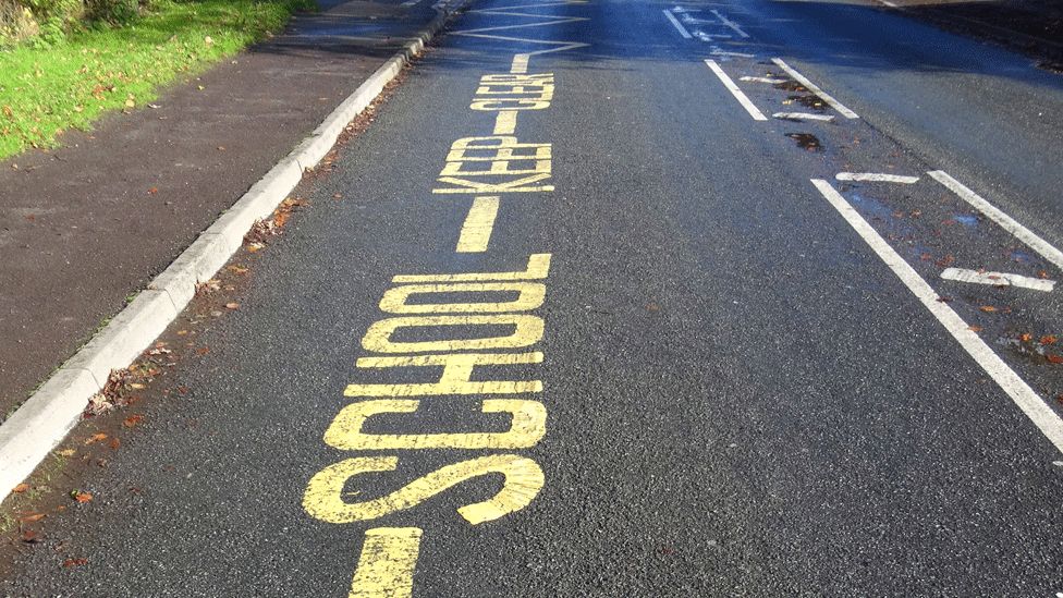 School parking writing and lines on road