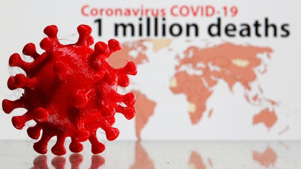 A 3D printed coronavirus model is seen in front of the words "Coronavirus COVID-19, one million deaths" on display in this illustration