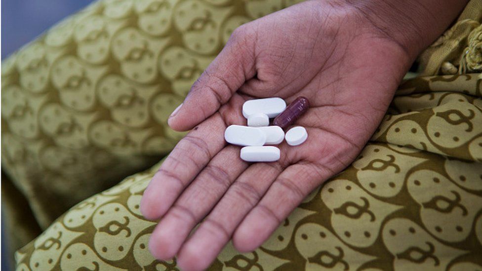 An Indian patient holds their daily Tuberculosis (TB) medication in the palm of their hand in a slum in Delhi, India.