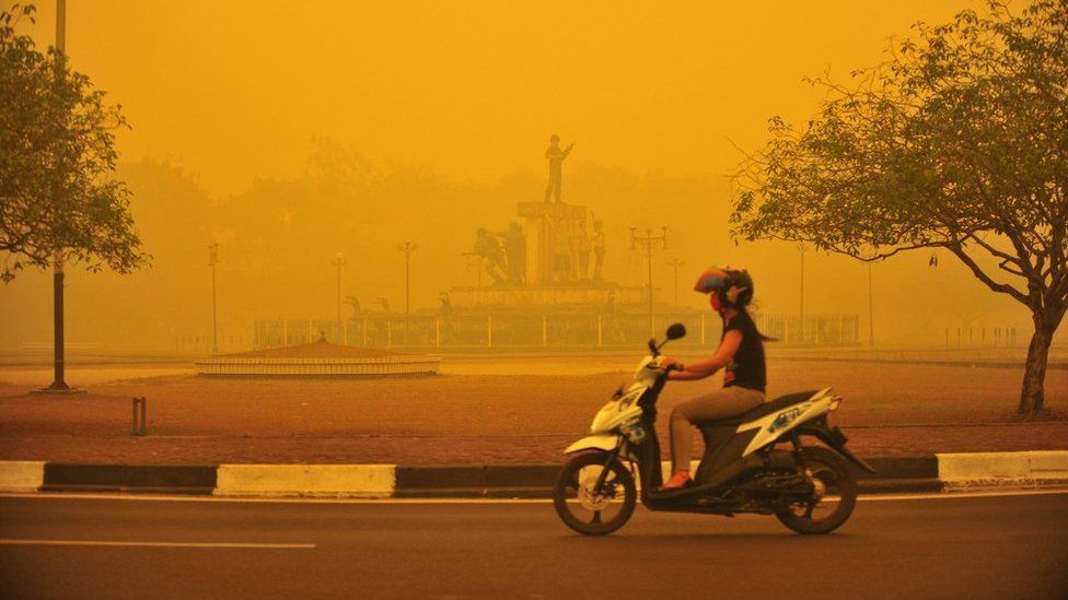 An Indonesian woman rides a motorbike amid thick yellow haze in Palangkaraya, Central Kalimantan province, Indonesia, 23 October 2015.
