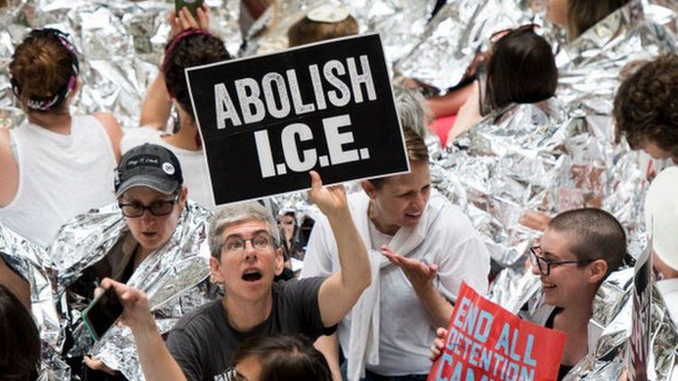 Protester holding sign saying Abolish Ice