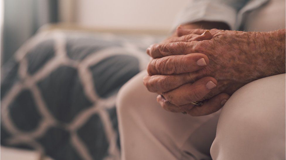 Cropped shot of a senior woman sitting with her hands clasped in a retirement home