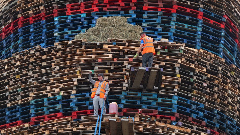 Final preparations are made to a huge bonfire in the loyalist Craigyhill area of Larne, Co Antrim, before it is lit on the "Eleventh night" to usher in the Twelfth commemorations.