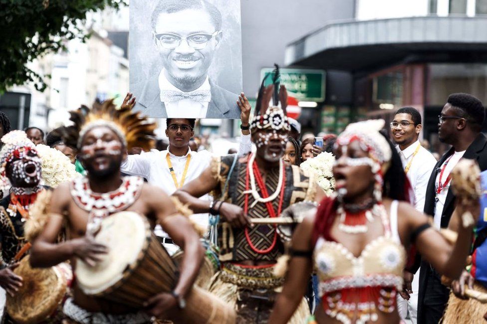 People take part in a march on 21 June 2022 to pay tribute to Patrice Lumumba (portrait) before the departure of his last remains to DR Congo in Brussels.