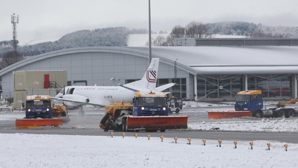 Snow ploughs clearing runway at Inverness Airport