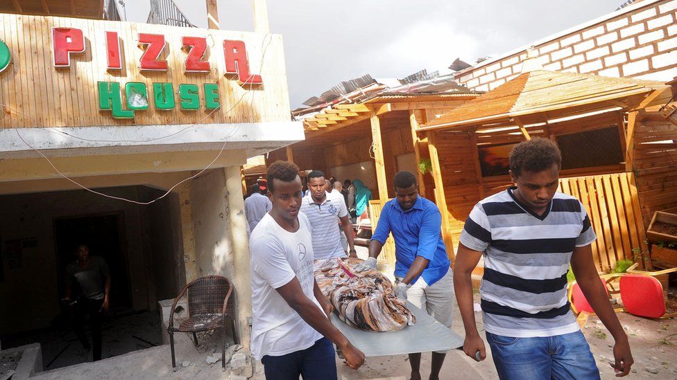 People carrying a body bag after the attack