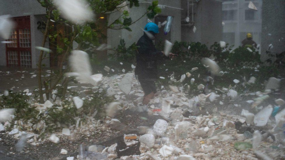A photojournalist walks through plastic debris blown by strong winds during Super Typhoon Mangkhut in Heng Fa Chuen in Hong Kong on September 16, 2018.