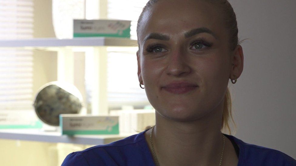 Zuzi Kam, a woman with ginger hair in a ponytail, sits inside a treatment room at So Me Beauty