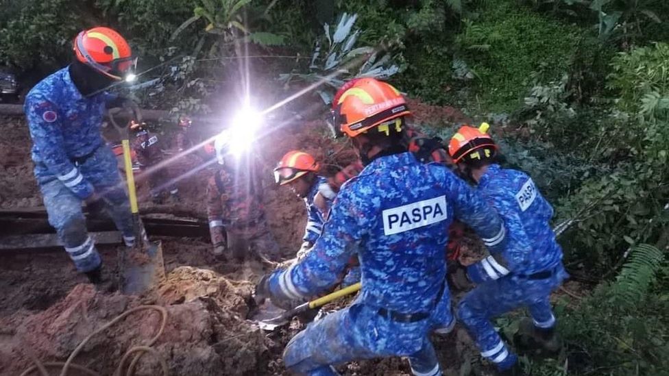 Emergency rescuers digging up ground in the search and rescue efforts at the landslide on 16/12