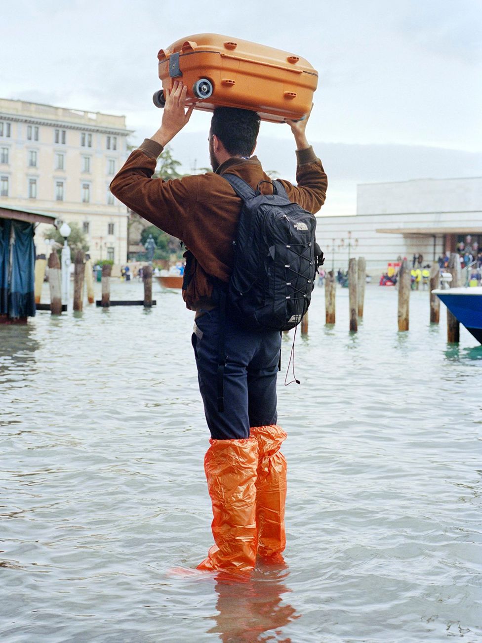 A man standing in high water in Venice, Italy.