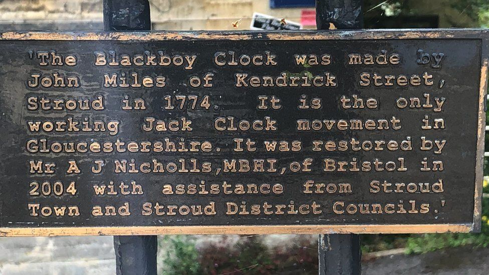 A plaque to the clock sits nearby