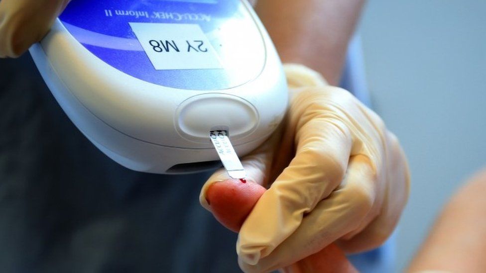 A diabetes tester pricking a finger