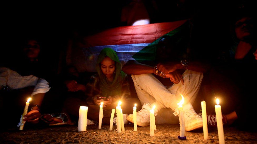 Sudanese protesters take part in a vigil in the capital Khartoum to mourn dozens of demonstrators killed in the raid on the Khartoum sit-in, 13 July