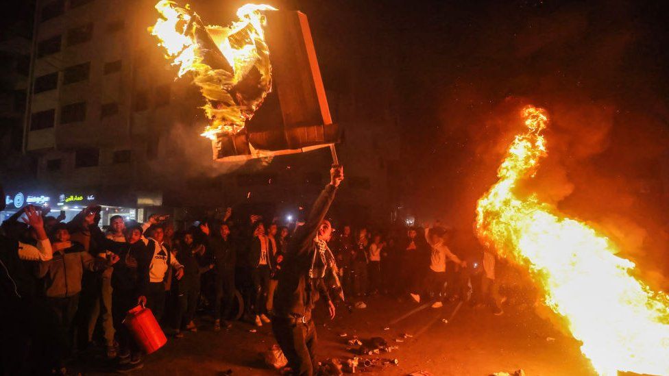 Палестинцы жгут шины и празднуют в городе Газа после того, как палестинский боевик открыл огонь возле синагоги в Восточном Иерусалиме