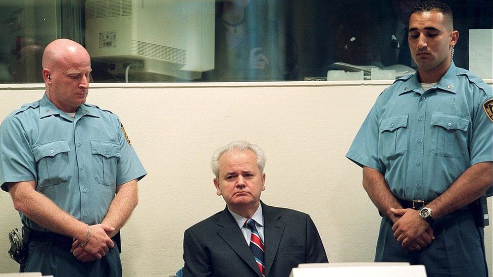 Slobodan Milosevic accompanied by two guards during a hearing in 2001 ahead of his trial in The Hague