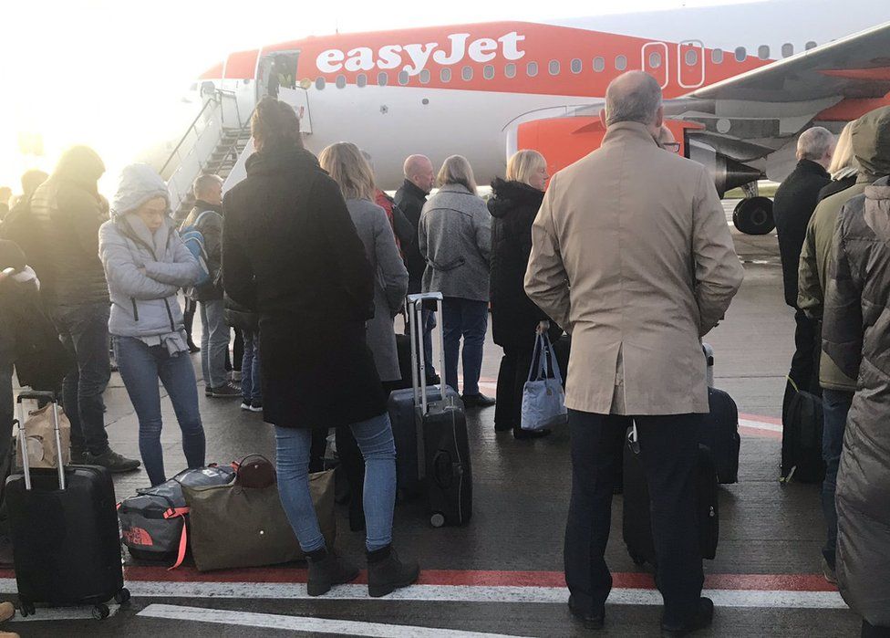 Passengers wait to board a flight in Liverpool after being forced to disembark