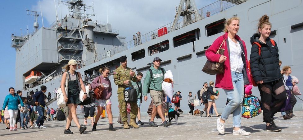 Evacuees leave HMAS Choules at the port of Hastings, Victoria