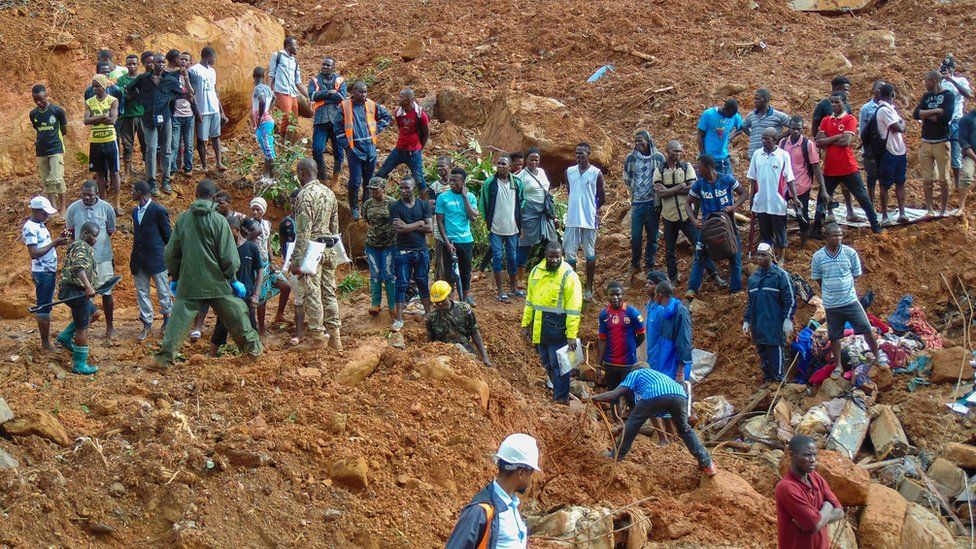 Residents and rescue personnel view damage caused by a mudslide in the suburb of Regent behind Guma reservoir, Freetown, Sierra Leone, 14 August 2017