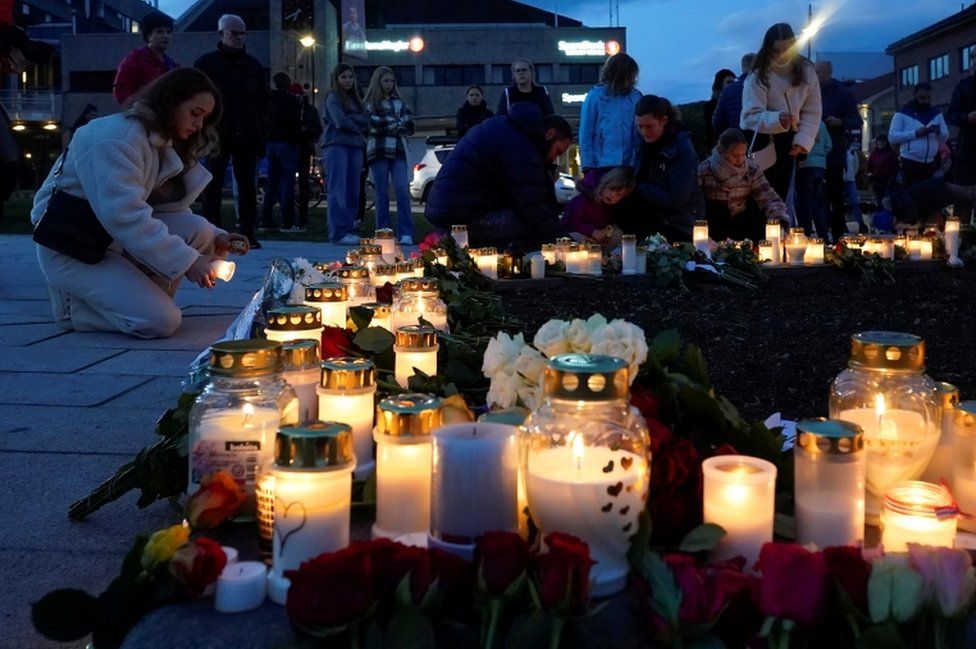 Люди кладут цветы и зажигают свечи после смертельного нападения в Конгсберге, Норвегия, 14 октября 2021 г.