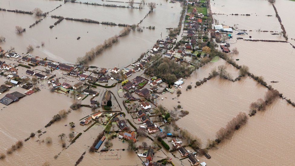 Drone shot of a village and farmland submerged in floodwater