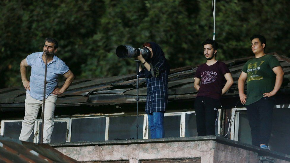 Image shows Parisa Pourtaherian taking photographs of the game