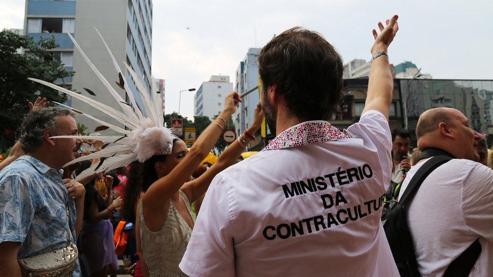 A man wears a T-shirt emblazoned with a fake government department, the "Ministry of Counterculture"