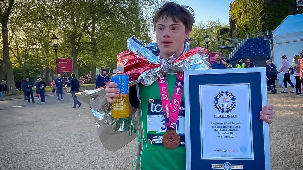 Lloyd in his running gear with a medal and a world record certificate