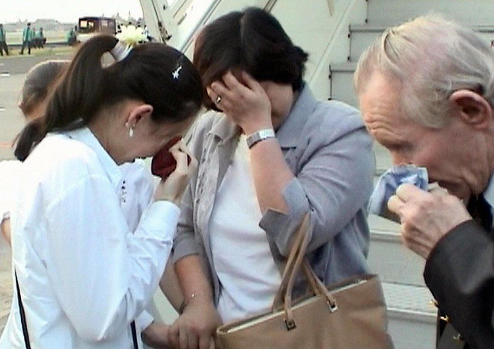 Hitomi Soga, Charles Jenkins, and their daughter Mika wipe away tears as they are reunited at Jakarta airport on 9 July 2004.