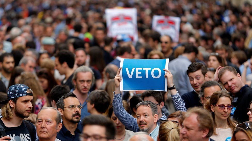 A demonstrator holds up a banner saying "Veto" during a rally against a new law passed by Hungarian parliament which could force the Soros-founded Central European University out of Hungary,