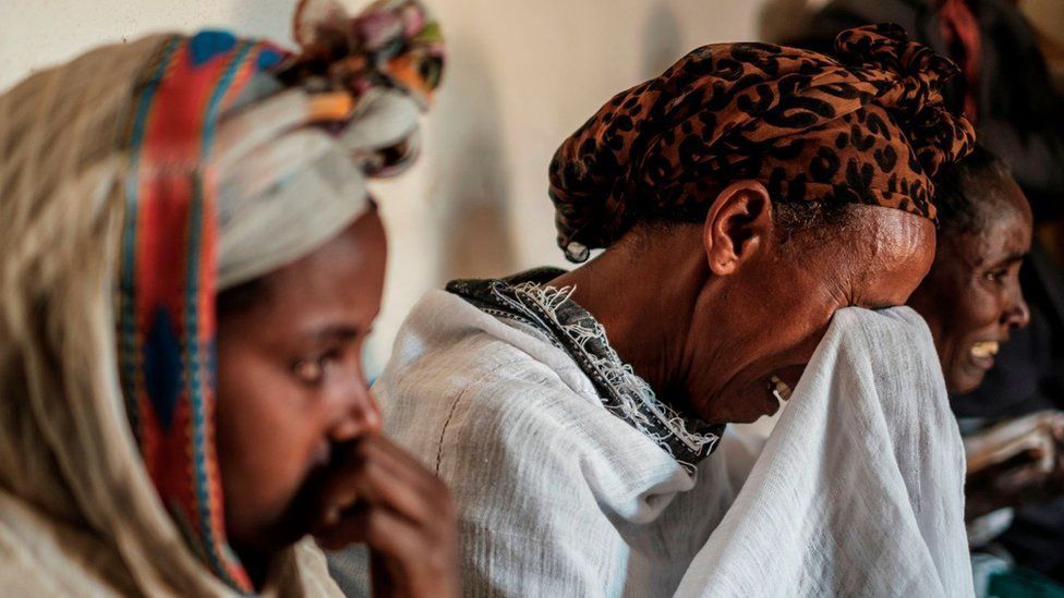 People mourn the victims of a massacre allegedly perpetrated by Eritrean Soldiers, at the house of Beyenesh Tekleyohannes, in the village of Dengolat, North of Mekele, the capital of Tigray on February 26, 2021