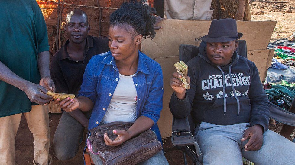 A gold buyer and gold digger trade in Malawian kwacha