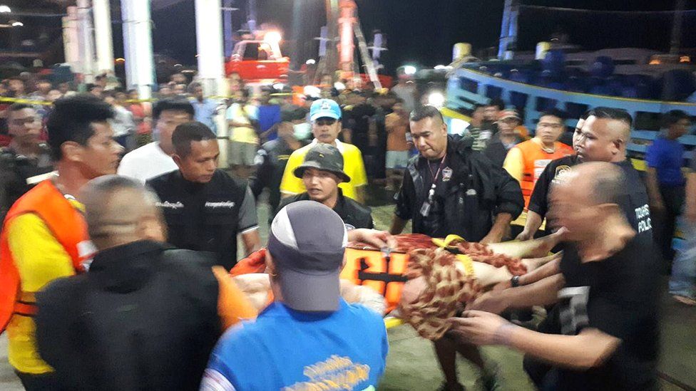 Thai rescue and paramedic personnel attend to passengers of capsized tourist boat in rough seas at a port in Phuket, Thailand, 5 July 2018