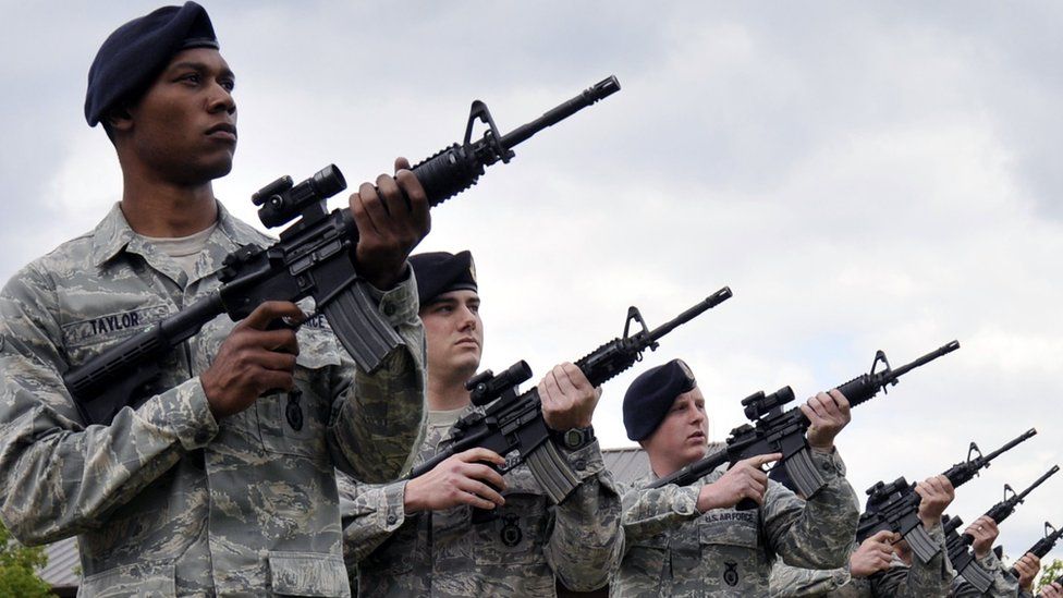 US service personnel carrying assault rifles