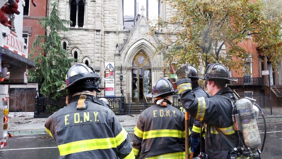 Firefighters stand in front of Middle Collegiate Church after a blaze gutted the building