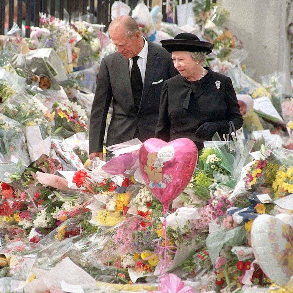 Королева и герцог Эдинбургский рассматривают цветы, посвященные Диане, принцессе Уэльской, в Букингемском дворце